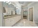 Spacious bathroom featuring double sinks, granite countertops, and access to a bedroom at 8642 W Fairway Woods Dr, North Charleston, SC 29420