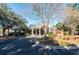 Elegant clubhouse entrance with a covered porch, lush landscaping, and a circular driveway at 8642 W Fairway Woods Dr, North Charleston, SC 29420