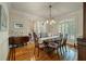 Formal dining room featuring a chandelier, hardwood floors, and elegant window shutters at 8642 W Fairway Woods Dr, North Charleston, SC 29420