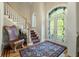 Elegant foyer with a staircase, stained glass door, and hardwood floors with decorative rug at 8642 W Fairway Woods Dr, North Charleston, SC 29420