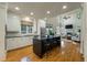 Bright kitchen with island seating, stainless appliances, custom cabinets, and access to the living room, perfect for entertaining at 8642 W Fairway Woods Dr, North Charleston, SC 29420