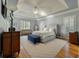 Serene main bedroom featuring a tray ceiling, large windows with shutters, and a cozy sitting area at 8642 W Fairway Woods Dr, North Charleston, SC 29420