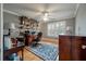 This home office has a traditional desk, shelving, wood floors, and plantation shutters at 8642 W Fairway Woods Dr, North Charleston, SC 29420