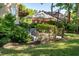 Serene patio area with umbrella-covered seating surrounded by vibrant landscaping at 8642 W Fairway Woods Dr, North Charleston, SC 29420