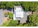 Aerial view showcases the house, surrounded by lush trees, featuring a rooftop deck, pool, and landscaped grounds at 9 24Th Ave, Isle of Palms, SC 29451