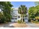 Beautiful multi-story home with a lush front yard featuring a tall palm tree and multiple garage doors at 9 24Th Ave, Isle of Palms, SC 29451