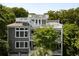 Multi-level house with grey siding, rooftop decks, white railings, and a well-maintained exterior surrounded by trees at 9 24Th Ave, Isle of Palms, SC 29451