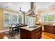 Stylish kitchen boasting a center island with a cooktop, complemented by dark wood cabinets and ample counter space at 9 24Th Ave, Isle of Palms, SC 29451
