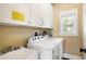 Well-lit laundry room with white cabinets, modern washer and dryer, and a convenient utility sink at 9 24Th Ave, Isle of Palms, SC 29451