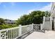 Spacious rooftop deck with white railings and stairs, offering stunning views of surrounding trees and neighborhood at 9 24Th Ave, Isle of Palms, SC 29451