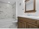Bright bathroom features a tub with marble tile surround and a wood vanity at 9000 Palmetto Drive # D-304, Isle of Palms, SC 29451