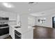 Open kitchen with stainless appliances, white cabinets, quartz counters and wood flooring at 9000 Palmetto Drive # D-304, Isle of Palms, SC 29451