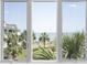 Bright view from a picture window overlooking palm trees, dunes, and the ocean at 9000 Palmetto Drive # D-304, Isle of Palms, SC 29451