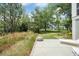 Picturesque backyard showcasing a stone patio, well-manicured lawn, and peaceful wooded surroundings at 1006 Basin Ln, Johns Island, SC 29455