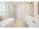 Bright bathroom with a soaking tub, glass shower, and double vanity at 1006 Basin Ln, Johns Island, SC 29455