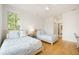 Bright bedroom featuring two twin beds, hardwood floors, white walls, and natural light from the window at 1006 Basin Ln, Johns Island, SC 29455