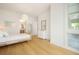 Airy bedroom with wood floors, rattan bed, and a view into an en suite bathroom at 1006 Basin Ln, Johns Island, SC 29455