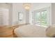 Bright bedroom featuring a rattan bed frame, wood floors and sun-drenched windows at 1006 Basin Ln, Johns Island, SC 29455