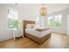 Bright bedroom with wood chandelier and a woven headboard, lit by natural light at 1006 Basin Ln, Johns Island, SC 29455