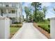 Long concrete driveway with decorative brick edging leads to a white home surrounded by well-maintained landscaping at 1006 Basin Ln, Johns Island, SC 29455