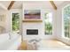 A stone fireplace with a painting above it is flanked by bright windows at 1006 Basin Ln, Johns Island, SC 29455