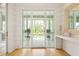 Bright foyer featuring wood floors, a decorative mirror, and a console table beneath large glass doors at 1006 Basin Ln, Johns Island, SC 29455
