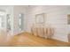 Inviting hallway showcasing light hardwood floors and a decorative stone console table beneath modern artwork at 1006 Basin Ln, Johns Island, SC 29455