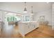 Spacious white kitchen with an island, farmhouse sink, and views into the dining and living areas at 1006 Basin Ln, Johns Island, SC 29455