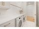 Well-lit laundry room with white cabinets, gold hardware, and front loading washer and dryer units at 1006 Basin Ln, Johns Island, SC 29455
