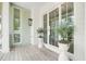 Charming porch featuring decorative plants in white planters, a wooden floor, and a stylish lantern at 1006 Basin Ln, Johns Island, SC 29455