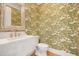 Stylish powder room with palm print wallpaper and a modern, marble-look sink at 1006 Basin Ln, Johns Island, SC 29455