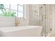 Shower with light-colored subway tiles and gold fixtures at 1006 Basin Ln, Johns Island, SC 29455