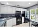 Well-lit kitchen featuring white cabinets and modern black appliances at 104 Buchanan Cir, Goose Creek, SC 29445