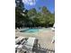Community pool surrounded by green trees with many chairs and tables for relaxation at 104 Buchanan Cir, Goose Creek, SC 29445