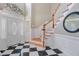 Bright foyer with a staircase, black and white tile, and wood accents throughout at 105 Aviary Ct, Summerville, SC 29483