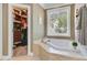 Bright soaking tub area with a large window and a walk-in closet, combining relaxation and organization at 105 Aviary Ct, Summerville, SC 29483