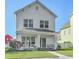 Charming two-story white home featuring a cozy front porch with seating and a well-manicured lawn at 107 Amaranth Ave, Summerville, SC 29483
