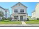 Charming two-story white home featuring a cozy front porch with seating and a well-manicured lawn at 107 Amaranth Ave, Summerville, SC 29483
