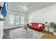 Bright living room featuring hardwood floors, a stylish red couch, and a ceiling fan at 107 Amaranth Ave, Summerville, SC 29483