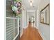 Inviting hallway featuring hardwood floors, neutral walls, and decorative mirror and a front door with a floral wreath at 112 Starling St, Summerville, SC 29483