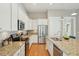Modern kitchen features white cabinets, granite countertops, stainless steel appliances, and hardwood flooring at 112 Starling St, Summerville, SC 29483