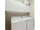 Functional laundry room with white washer, dryer, and overhead storage cabinets at 112 Starling St, Summerville, SC 29483