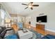 Spacious living room with hardwood floors, large windows, ceiling fan, and an open connection to the kitchen at 112 Starling St, Summerville, SC 29483
