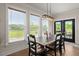 Bright dining area featuring a rustic wood table, stylish light fixture, and large windows with scenic views at 118 Jesup Ct, Ridgeville, SC 29472