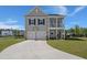 Charming two-story home with a front porch, two-car garage, basketball hoop, and a well-manicured lawn at 118 Jesup Ct, Ridgeville, SC 29472