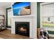 Modern fireplace with decorative mantle, TV, and windows overlooking a well-maintained yard at 118 Jesup Ct, Ridgeville, SC 29472