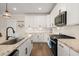 Bright kitchen with white cabinets, granite countertops, stainless appliances, and modern fixtures at 118 Jesup Ct, Ridgeville, SC 29472