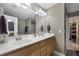 Bathroom with double sinks, white countertop, wooden cabinets, and access to the walk-in closet and shower at 118 Netherfield Dr, Summerville, SC 29486