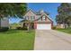 Charming two-story home with a well-manicured lawn, a two-car garage, and beautiful landscaping at 118 Netherfield Dr, Summerville, SC 29486