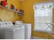 Bright laundry room with washer, dryer, storage shelves, and a sunny window at 118 Netherfield Dr, Summerville, SC 29486